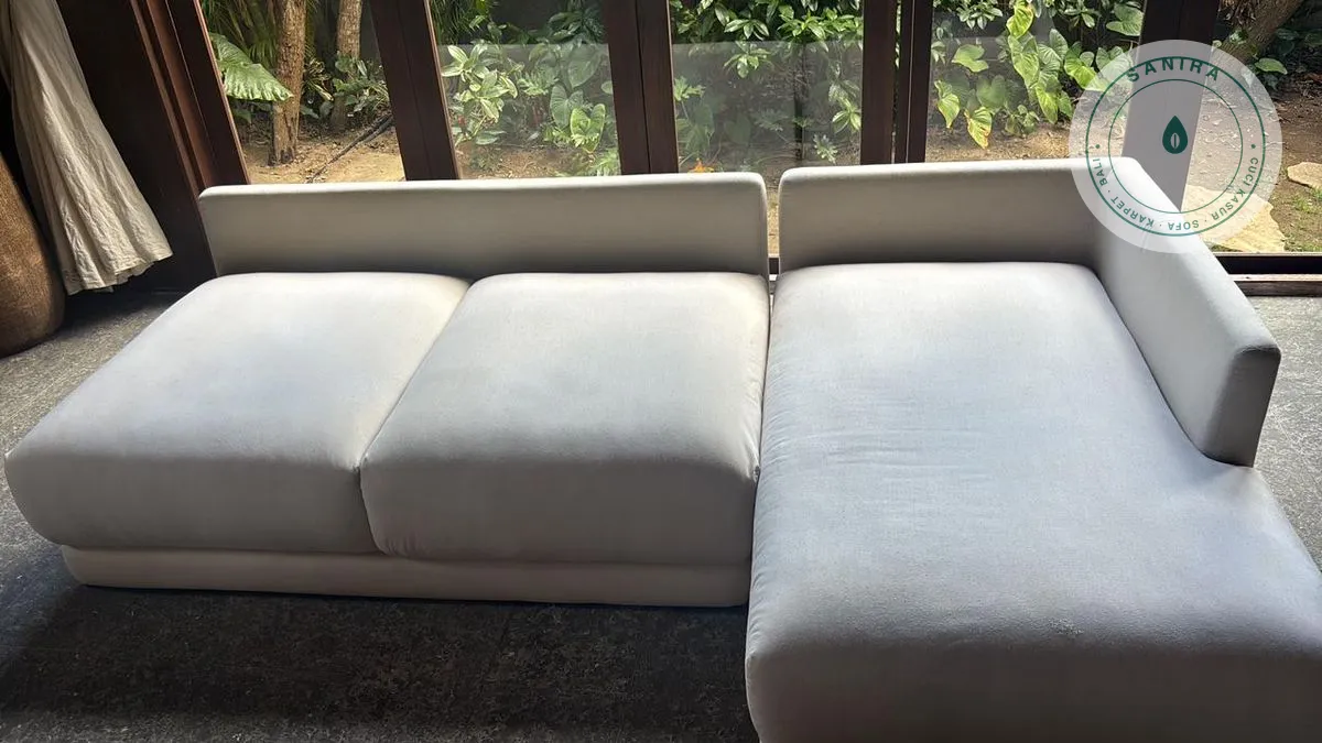 Sofa kain krem bersih di ruang semi-outdoor bergaya Bali, rentan lembap kalau ventilasi kurang
