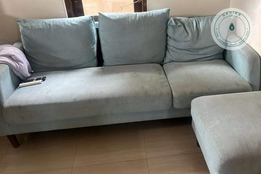 Sofa hijau mint dengan dudukan bernoda gelap sebelum dicuci Sanira