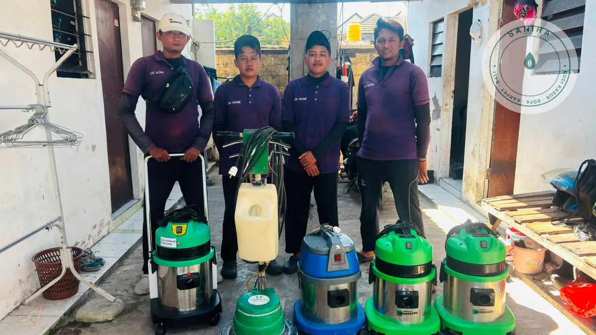 Empat anggota tim lapangan dengan mesin ekstraksi dan peralatan pembersihan